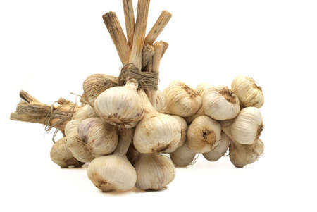 Braided garlic bulbs bonded with jute rope ready for storage isolated on white backgroundの写真素材