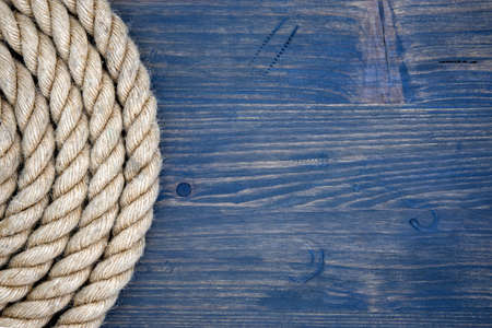 Braided natural jute rope over a rustic wood background with copy space viewed top downの写真素材
