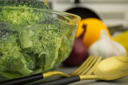 Fresh broccoli florets soaked in a clear bowl of water. Selective focus macro shotの写真素材