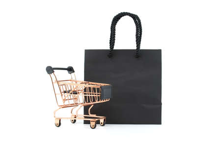 Shopping cart and black paper shopping bag isolated on white background. Black Friday sale, shopping conceptの写真素材