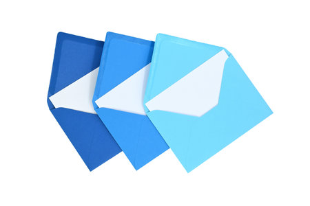 Envelopes of blue hues with blank white card isolated on white background, viewed from above. Top viewの写真素材