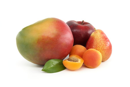 Whole and halved ripe apricot, pear, mango fruit and red apple isolated on a white backgroundの写真素材