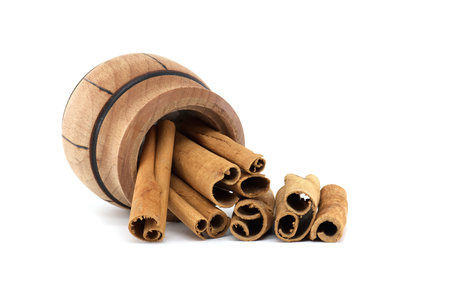 Cinnamon sticks in a small wooden pot isolated on white backgroundの写真素材