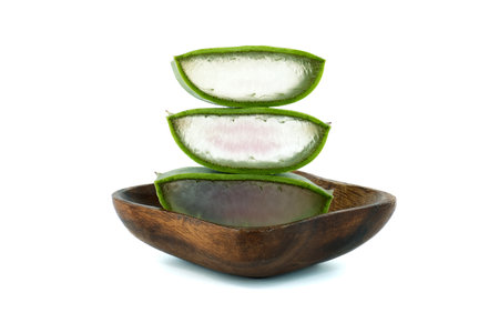 Aloe Vera leaf slices in wooden plate isolated on white background, organic cosmetic ingredients, alternative medicineの写真素材