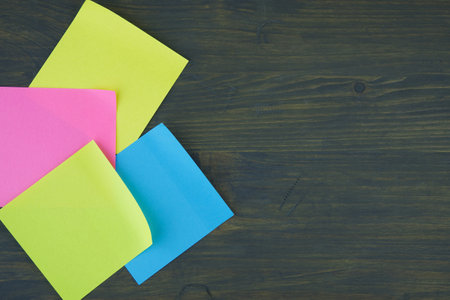 Empty color office paper for notice with curled corners on rustic board. Free copy space for text