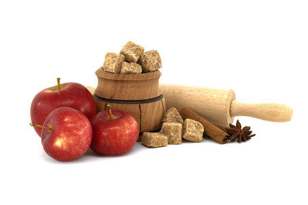 Red apples, sugar, cinnamon sticks and anise stars near rolling pin in a food still life on white, conceptual of a baking apple pieの写真素材