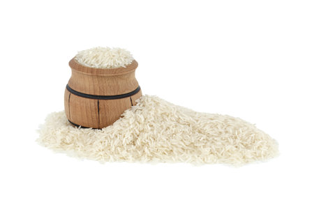 Dry long-grain rice in small wooden barrel isolated on white backgroundの写真素材
