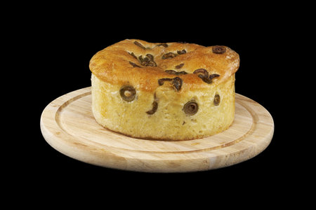 Round focaccia bread with olives over black backgroundの写真素材