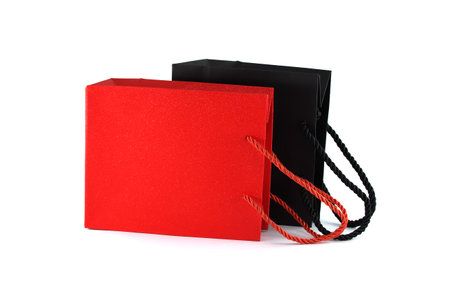 Black and red paper shopping bags isolated on white background. Gifts and shopping conceptの写真素材