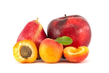 Whole and halved ripe apricot, pear and red apple isolated on a white backgroundの写真素材