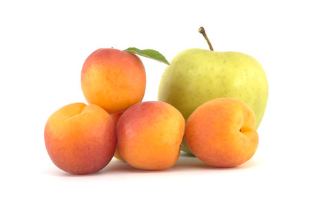 Whole ripe apricots and green apple isolated on a white background, various fruits for a multivitamin mixの写真素材