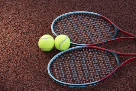 Top view tennis scene with two yellow tennis balls and two racquets on hard tennis court surfaceの写真素材