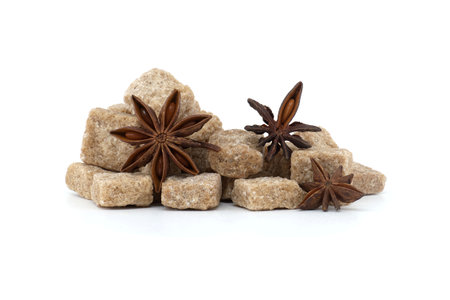Natural raw brown cane sugar cubes and anise star with a seed inside isolated on white backgroundの写真素材