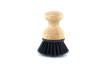 Highly detailed perspective image of dish brush with black bristles, intended for scrubbing dishes or other objects with hard-to-clean surfacesの写真素材
