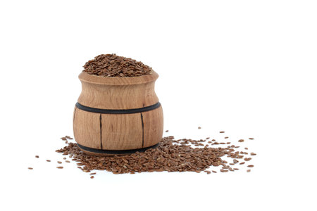 Linseed in small wooden barrel isolated on white backgroundの写真素材