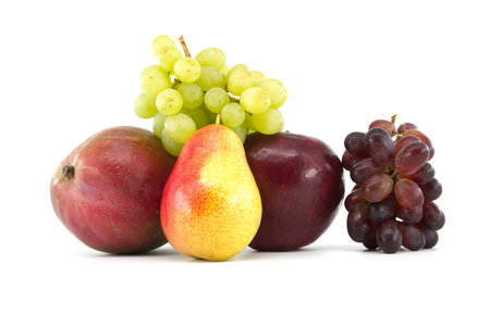 Fresh multicolored ripe pears and mango fruits, red and green grapes isolated on white background. Multivitamin and juicy rich fruitsの写真素材