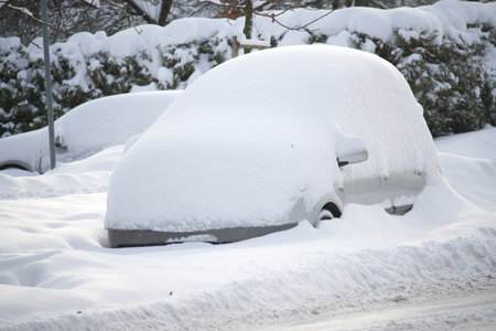 Winter's day with multiple cars, some cars are almost entirely buried by the snowの写真素材