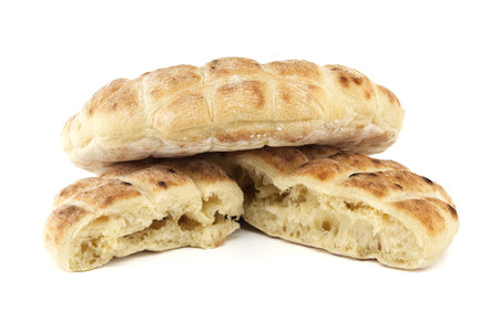 Stack of round pita flat-breads isolated on a white background, pita bread has a pocket and is cut...