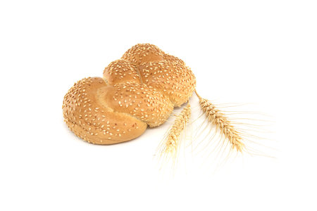Braided sesame bun and a stalks of wheat isolated on white backgroundの写真素材