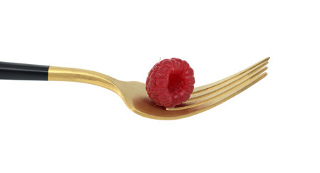 Red raspberry arranged on gold fork with a black handle, set against a white background, symbolizing a concept of healthy diet and organic foodの写真素材