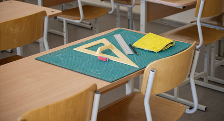 Classroom desk showcasing math tools such as a ruler and set square, along with an eraser and...