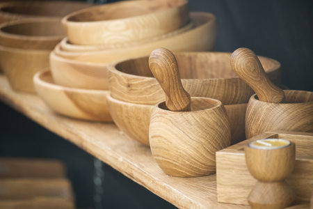Collection of wooden bowls and mortars with pestles. Displayed with emphasis on natural wood grain and craftsmanship ideal for rustic decor or culinary use. Traditional elegance and functionalityの写真素材
