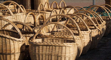 A collection of traditional handcrafted wicker baskets on display under sunlight at an outdoor market, showcasing sustainable and eco-friendly craftsmanship.の写真素材