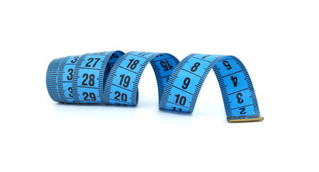 A vibrant blue measuring tape is artistically rolled and unrolled against a clean white background....