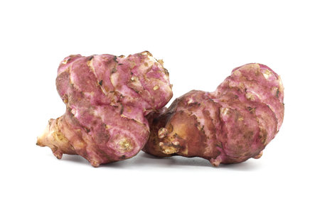 Detailed image of two fresh pink Jerusalem artichokes against a white background. Perfect for culinary, botanical, and healthy eating concepts. Highlights texture and natural color of these unique tubersの写真素材