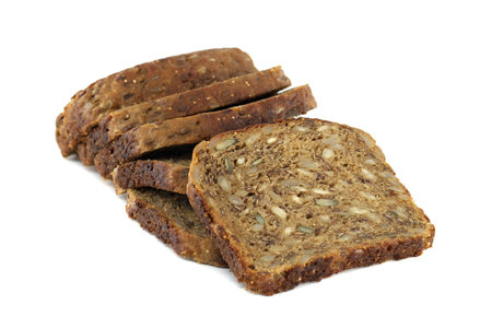 A stack of several slices of fresh, dark, multigrain bread, full of healthy seeds, stands out...