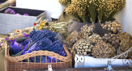 A still life of lavender and dried flowers in rustic containers on a table evokes a sense of natural beauty and artisanal craftsmanship.の写真素材