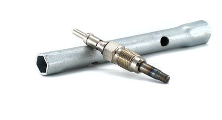 Close-up of a diesel engine glow plug with a socket tool used for installation or maintenance,...