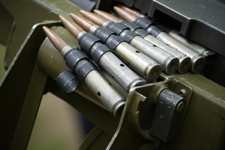 An up-close view displays machine gun rounds neatly lined up, ready for action, inside a military...