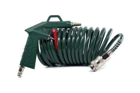Industrial green air hose and blower gun coiled for efficient use in various professional applications. Lightweight and durable design providing reliable service for pneumatic systems and toolsの写真素材