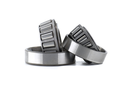 A close-up of several tapered roller bearings isolated on a clean white background, illustrating mechanical parts.の写真素材