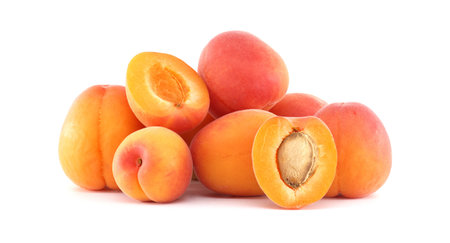A collection of fresh, ripe apricots, some halved to reveal the juicy interior, against a clean white background.の写真素材