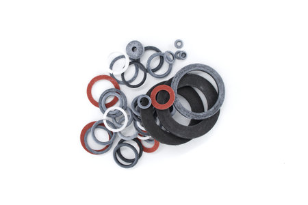 A top-down shot displays a diverse collection of rubber gaskets in various sizes and colors against...