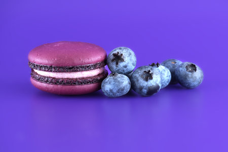 French macaroons and blueberries over purple backgroundの写真素材
