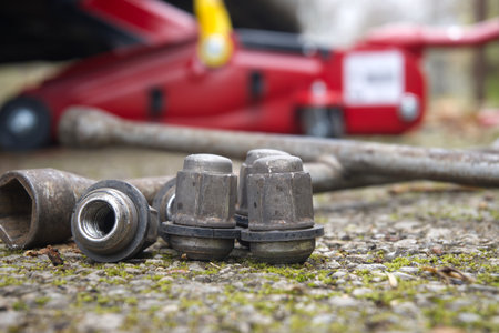 The tools and lug nuts are placed on the ground, ready for a tire change