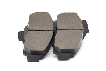 Close-up of automotive brake pads on a white background, suitable for car repair, maintenance, and parts catalogs. Shows pad surface texture and metal backing for replacement and inspection.の写真素材