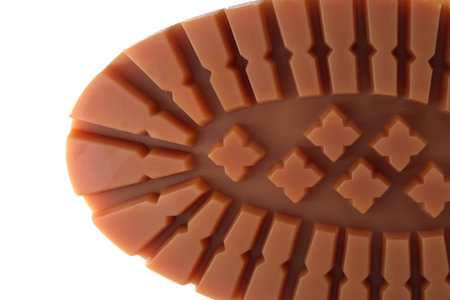 A macro shot showing the brown rubber shoe sole with deep, angular tread and distinctive pattern. Great for topics like footwear, grip, traction, and outdoor soles.の写真素材