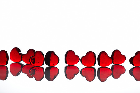 Red glass hearts on white background