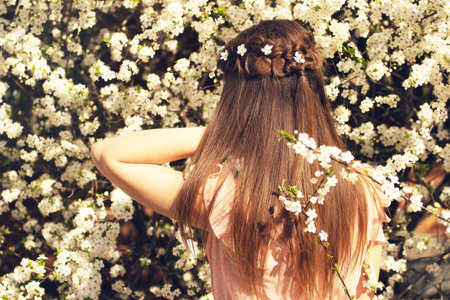 Natural beauty. Portrait of beautiful and young long-haired girl correcting her flowers standing...