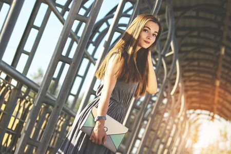 Elegant and charming woman posing outdoors in the city. Urban fashion concept. Big city life. Trendy and beautiful woman walking in the city.の写真素材