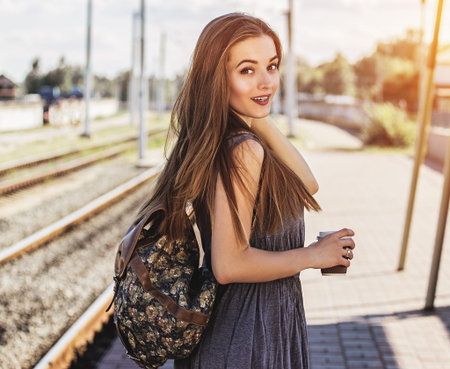 Gorgeous girl ready for new adventures. Side view of beautiful young woman with backpack on her back...