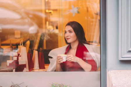 Portrait happy young beautiful woman open gift box, look in window and smile in mall restaurant....