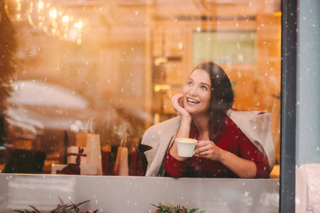 Portrait happy young beautiful woman open gift box, look in window and smile in mall restaurant....