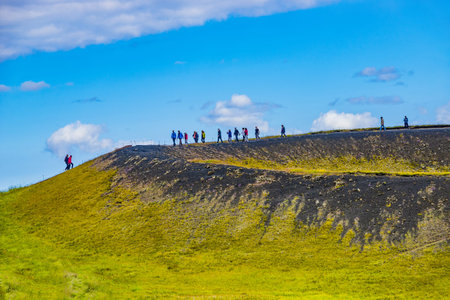 Tourists at the top of pseudo craters aka volcanic near Skutustadir and lake Myvatn on Iceland