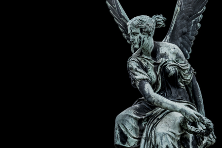 Statue of ancient beautiful winged angel in downtown of Potsdam, isolated at black background, Germanyの写真素材