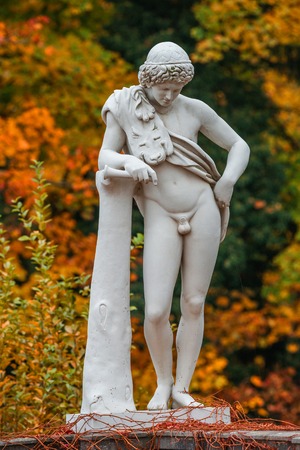 Statue of sensual renaissance era Roman man in lion skin with hunting tube at golden Autumn, Potsdam, Germanyの写真素材